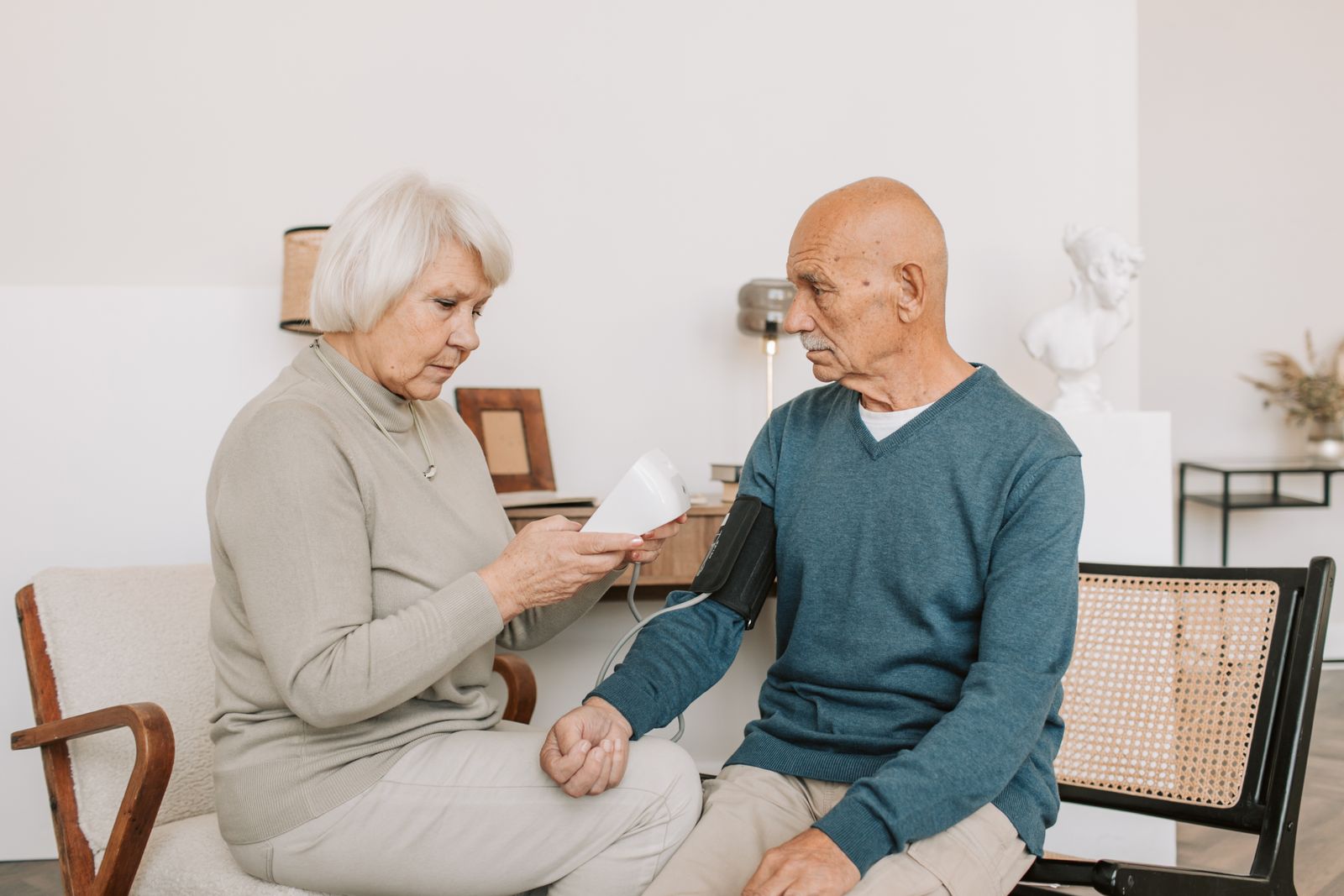 A couple at home taking a blood pressure reading with an arm cuff